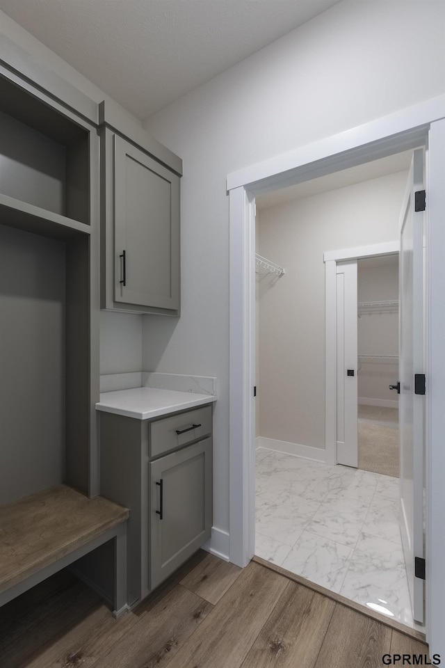 mudroom with marble finish floor and baseboards