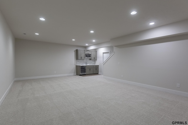 unfurnished living room with light carpet, wine cooler, and recessed lighting