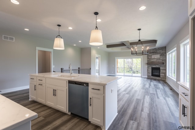 kitchen with dark wood finished floors, visible vents, stainless steel dishwasher, a sink, and coffered ceiling