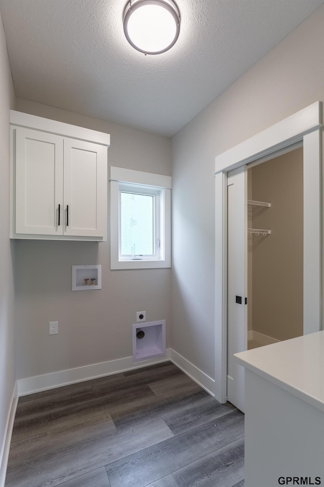 laundry room featuring hookup for a washing machine, baseboards, cabinet space, dark wood finished floors, and electric dryer hookup