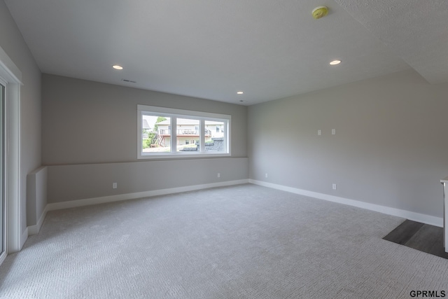 unfurnished room with light carpet, recessed lighting, and baseboards