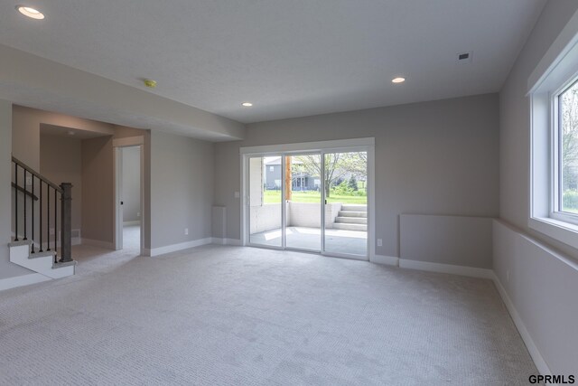 unfurnished room with light carpet, baseboards, stairway, and recessed lighting