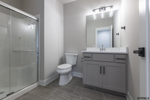 full bathroom featuring toilet, a shower stall, baseboards, and vanity