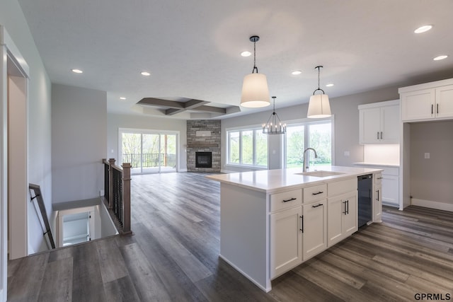 kitchen with dark wood finished floors, recessed lighting, white cabinetry, a sink, and coffered ceiling