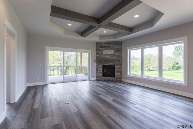 unfurnished living room with dark wood-style floors, baseboards, coffered ceiling, and a wealth of natural light