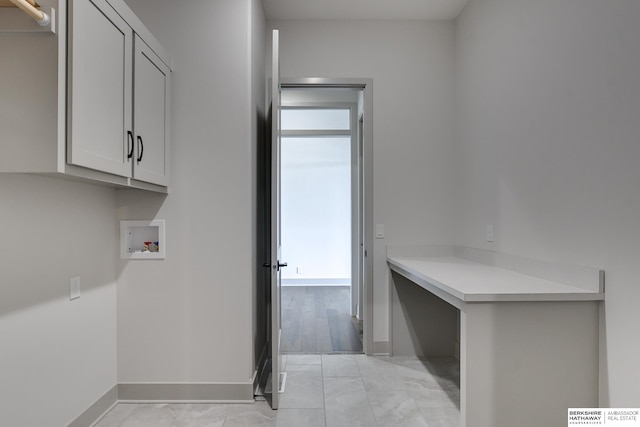 clothes washing area with hookup for a washing machine, light hardwood / wood-style floors, and cabinets