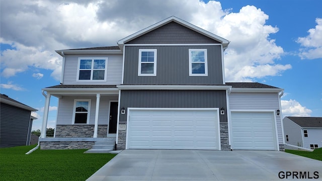 view of front of house with a garage, a porch, and a front yard