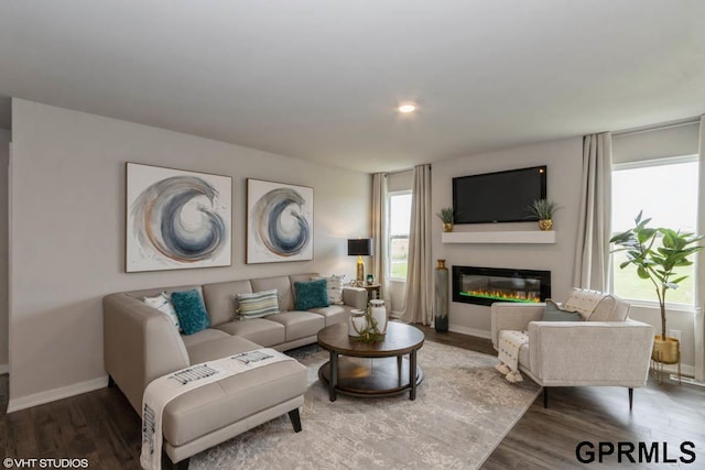 living room featuring a wealth of natural light and dark hardwood / wood-style flooring