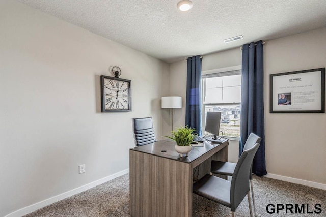 carpeted office space with visible vents, baseboards, and a textured ceiling