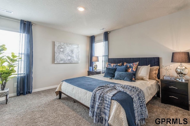 bedroom with visible vents, carpet floors, a textured ceiling, and baseboards