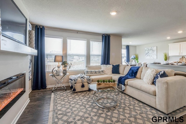 living room with dark wood finished floors, recessed lighting, baseboards, and a textured ceiling