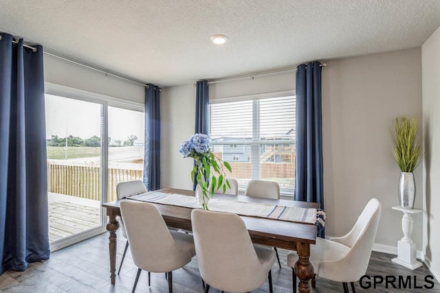 dining space featuring a textured ceiling and light wood-style flooring