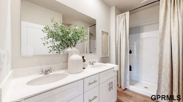 bathroom with vanity, a shower with shower curtain, and hardwood / wood-style floors