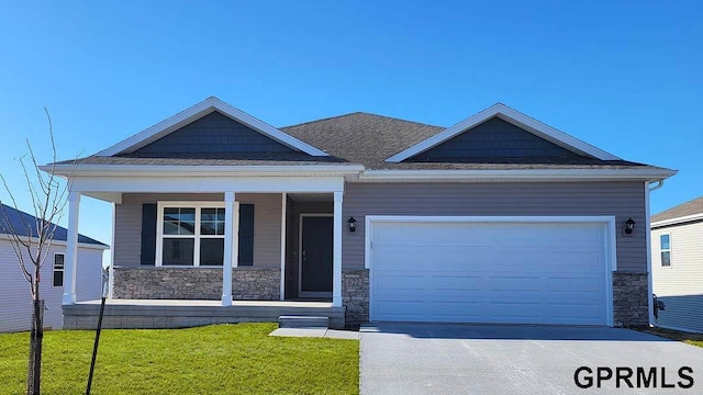 view of front of home featuring concrete driveway, an attached garage, stone siding, and a front yard