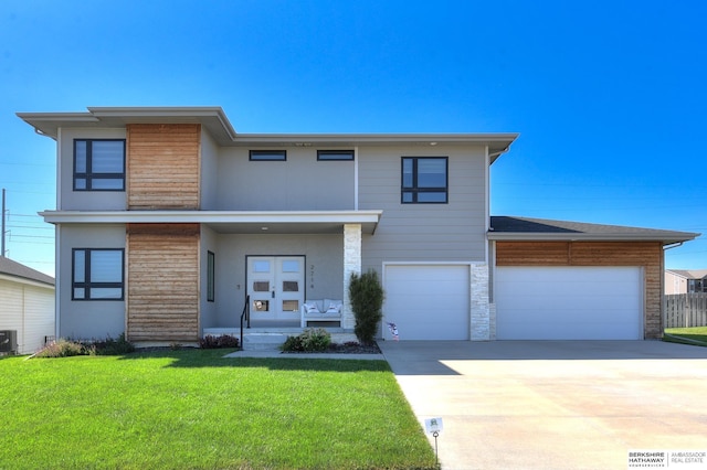 view of front of home with french doors, central air condition unit, a front yard, stone siding, and driveway