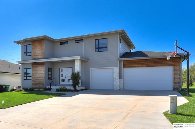 view of front of home featuring a garage, stone siding, concrete driveway, and a front yard