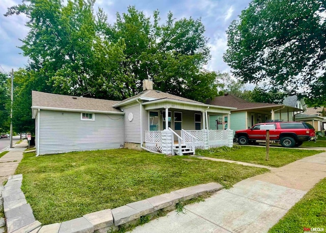 view of front of home with covered porch and a front yard