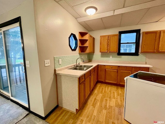 kitchen featuring light hardwood / wood-style flooring, sink, electric stove, a drop ceiling, and decorative backsplash