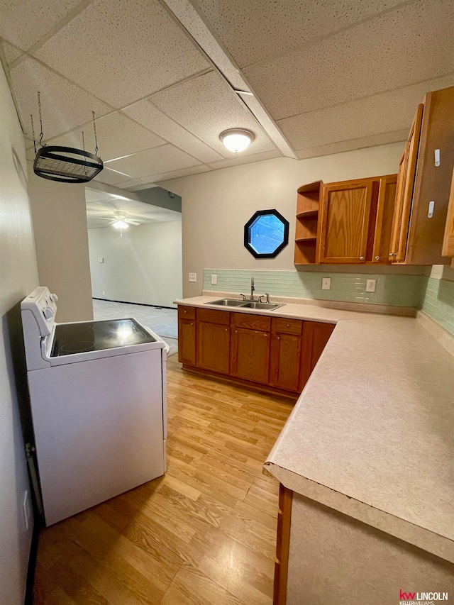 kitchen with a drop ceiling, white electric range, light hardwood / wood-style flooring, sink, and washer / clothes dryer