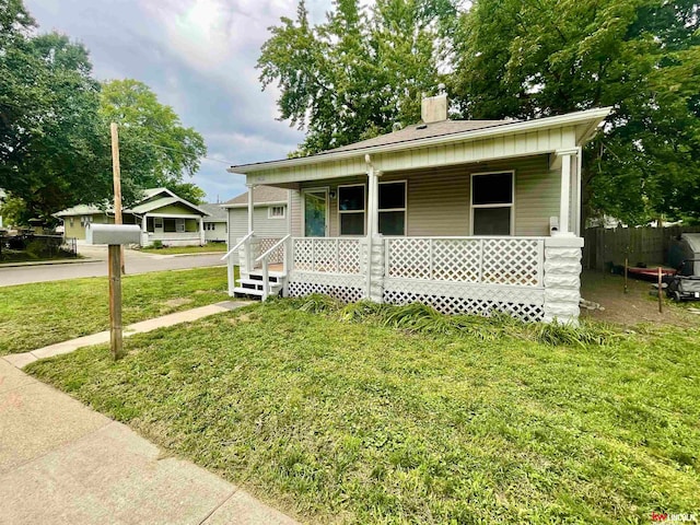 bungalow featuring a front yard and covered porch