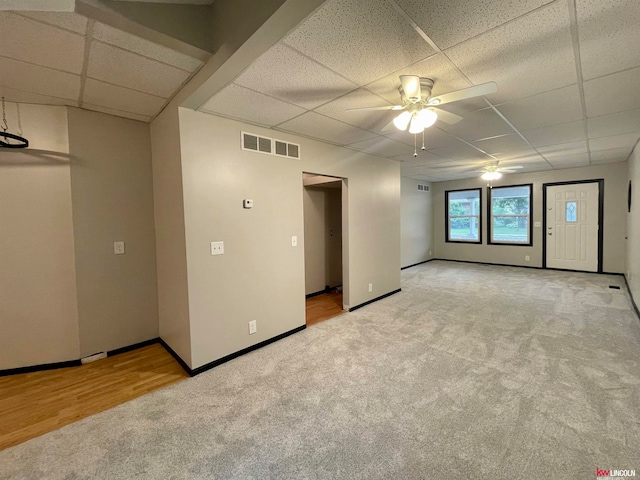 unfurnished room featuring light hardwood / wood-style flooring, ceiling fan, and a paneled ceiling