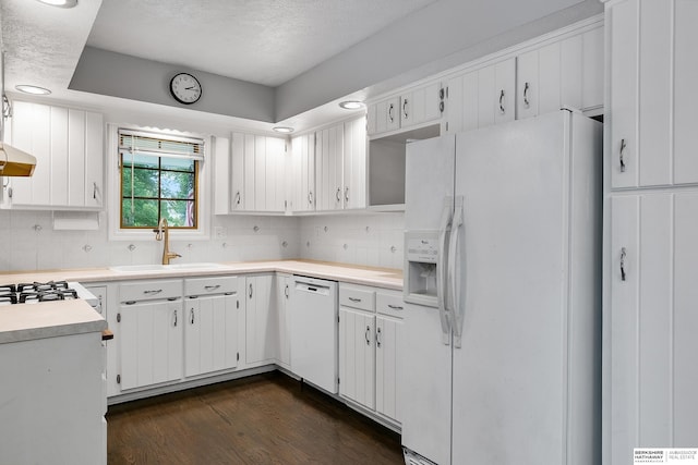 kitchen with white appliances, sink, white cabinets, and dark hardwood / wood-style floors