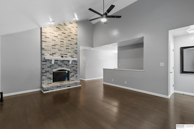 unfurnished living room with dark hardwood / wood-style flooring, a brick fireplace, high vaulted ceiling, and ceiling fan