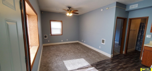 spare room with dark carpet and ceiling fan