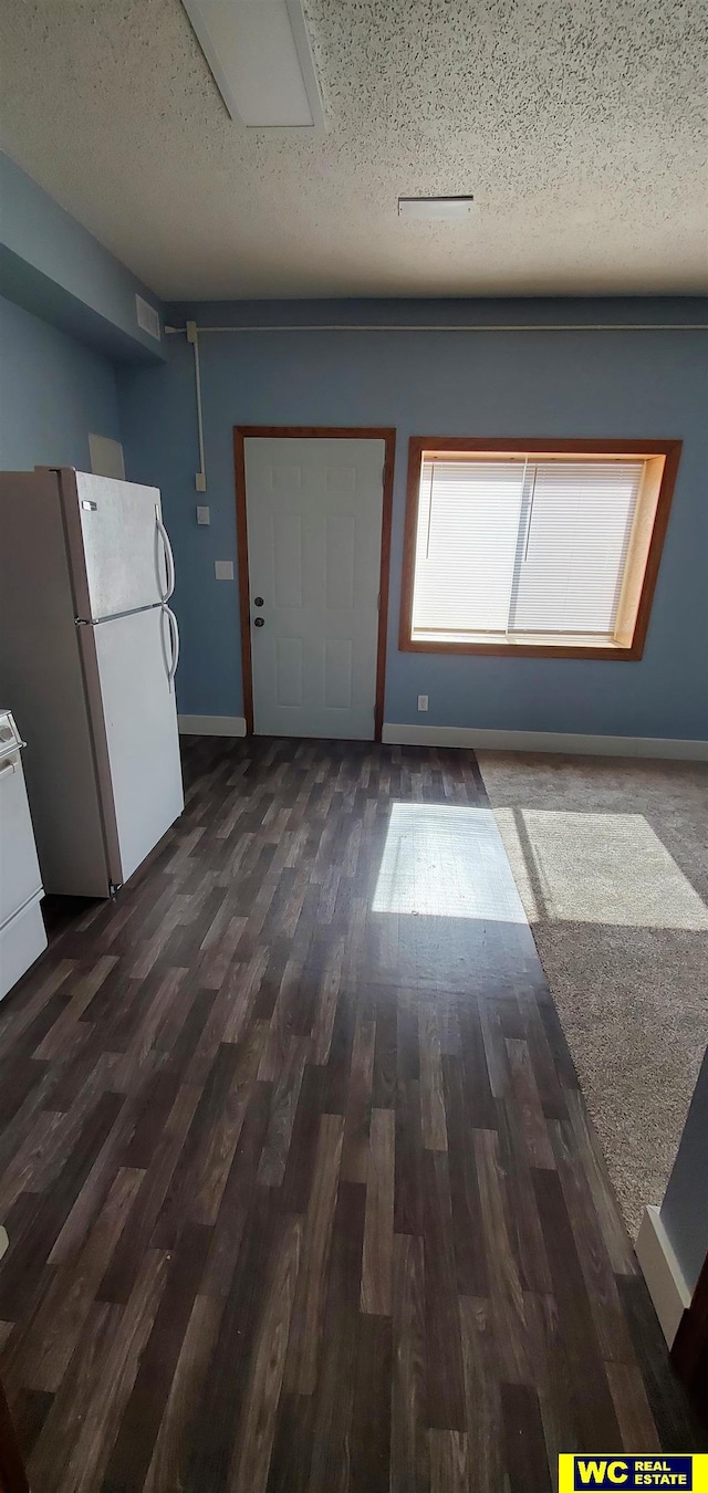 foyer entrance featuring dark hardwood / wood-style flooring and a textured ceiling