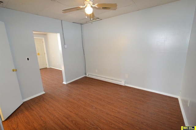 unfurnished room featuring baseboard heating, dark hardwood / wood-style floors, and ceiling fan