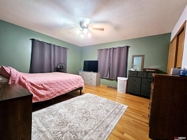 bedroom featuring visible vents, a textured ceiling, a ceiling fan, and light wood finished floors