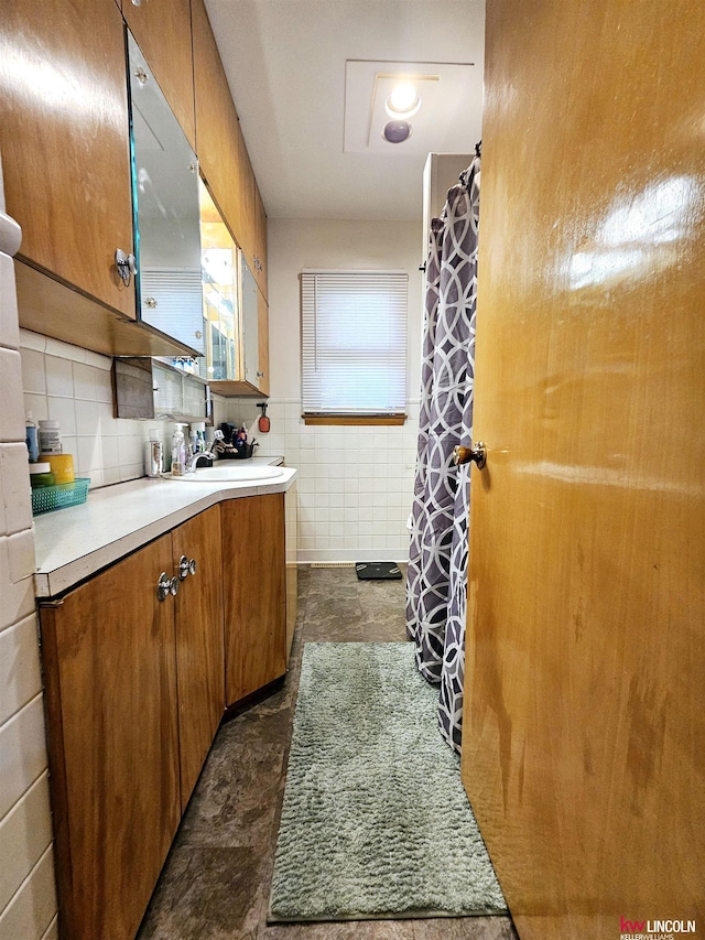 bathroom with a shower with shower curtain, vanity, and tile walls