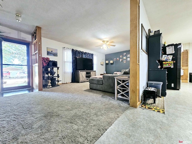 living room with a textured ceiling and a ceiling fan