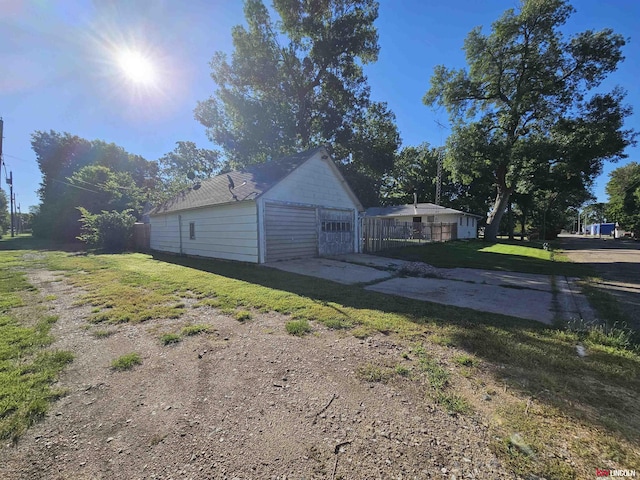 view of side of property featuring a yard, a garage, and driveway