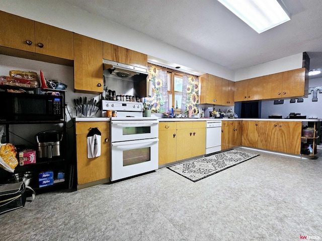 kitchen featuring black microwave, light floors, light countertops, range with two ovens, and brown cabinets