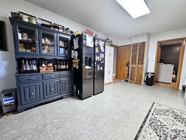 bar featuring refrigerator with ice dispenser, washer / clothes dryer, and tile patterned floors