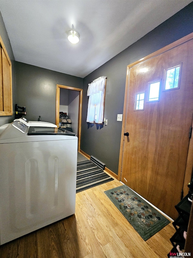 laundry room featuring cabinet space, baseboards, washer / dryer, and wood finished floors