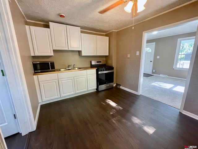 kitchen with white cabinets, dark wood-type flooring, stainless steel appliances, and ceiling fan