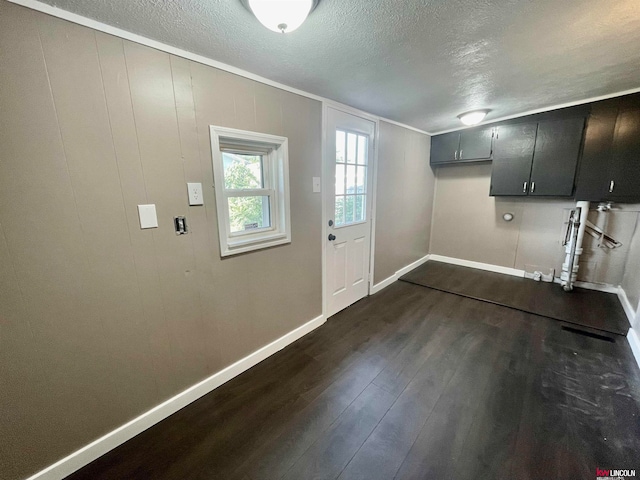 interior space with wooden walls, dark hardwood / wood-style floors, and a textured ceiling