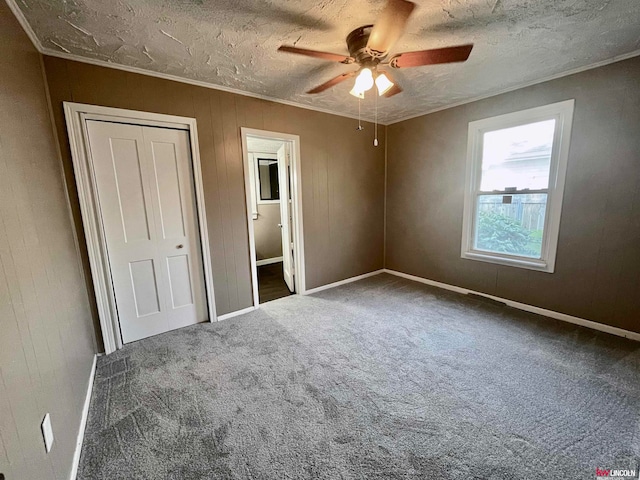 unfurnished bedroom featuring ceiling fan, carpet floors, and a textured ceiling