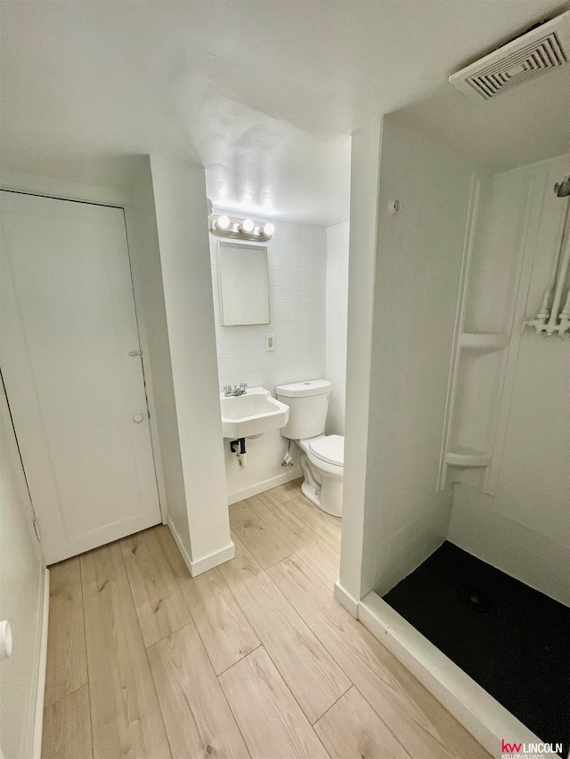 bathroom with walk in shower, toilet, hardwood / wood-style floors, and sink