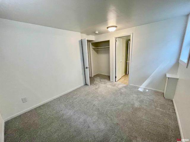 unfurnished bedroom with light colored carpet and a closet