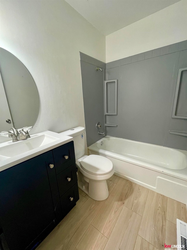 full bathroom featuring vanity, toilet, hardwood / wood-style floors, and shower / tub combination