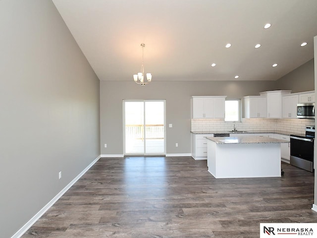 kitchen with a healthy amount of sunlight, a kitchen island, appliances with stainless steel finishes, and a sink