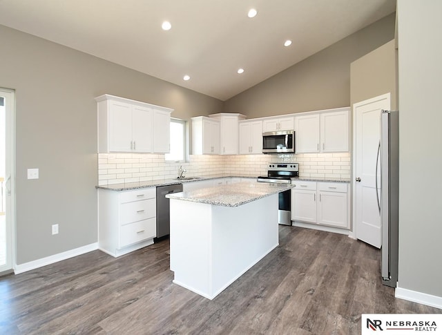 kitchen with a kitchen island, stainless steel appliances, dark wood-type flooring, and a sink