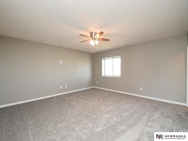 carpeted spare room featuring a ceiling fan and baseboards