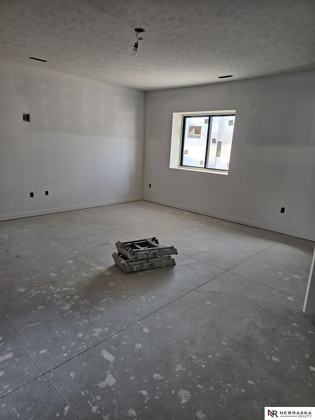 unfurnished room featuring visible vents and a textured ceiling