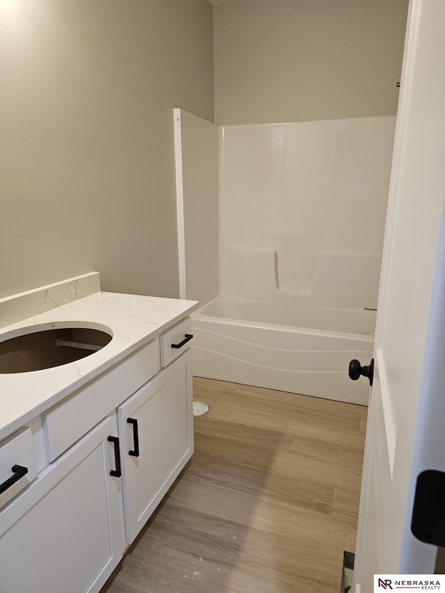 full bath with vanity, shower / tub combination, and wood finished floors