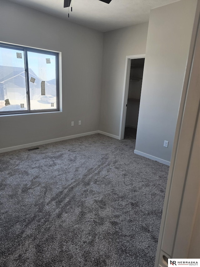 spare room featuring carpet flooring, visible vents, baseboards, and ceiling fan