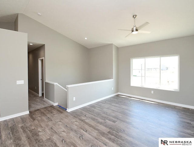 unfurnished room featuring ceiling fan, baseboards, lofted ceiling, and wood finished floors